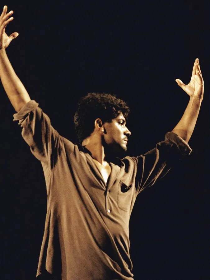 Homem dançando dança contemporânea sozinho em um palco escuro