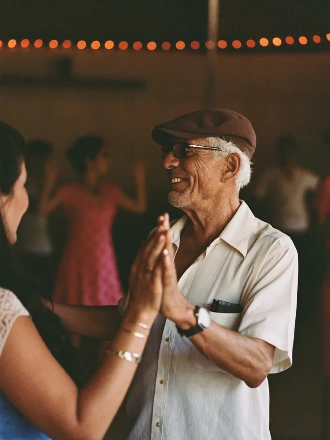 Senhor de boné dançando forró em um baile comunitário